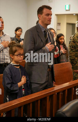 CAMP FOSTER, Okinawa, Japon- un père et fille de réciter le serment d'allégeance au cours d'une cérémonie de naturalisation le 31 janvier Camp à bord de Foster, Okinawa, Japon. Familles et amis se sont réunis pour soutenir leurs proches dans leur dernière étape en vue de devenir citoyens américains. Onze candidats provenant de sept pays différents se tenait devant leur famille, ont levé la main droite et a répété le serment d'allégeance à l'obtention de leur citoyenneté. (U.S. Marine Corps Banque D'Images