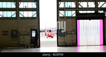 Maître de 3e classe Dylan Melton, un mécanicien de vol, ferme une porte du hangar à Washington D.C., le 30 janvier 2018. Les équipages d'Air Station Atlantic City soutenir la région de la capitale nationale de la défense aérienne (NCRADF) en fournissant de multiples aéronefs pour aider la défense aérospatiale de l'Amérique du Nord (NORAD). U.S. Coast Guard photo de Maître de 3e classe David Micallef Banque D'Images