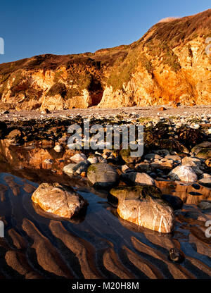 Falaises d'or et de sable à l'Église Bay, Anglesey, Pays de Galles au soleil d'été sous un ciel bleu Banque D'Images