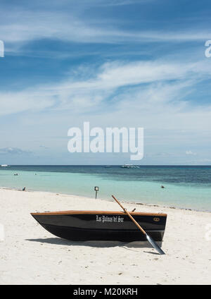 Bateau à rames allongé sur une plage tropicale avec un océan calme dans l'arrière-plan Banque D'Images
