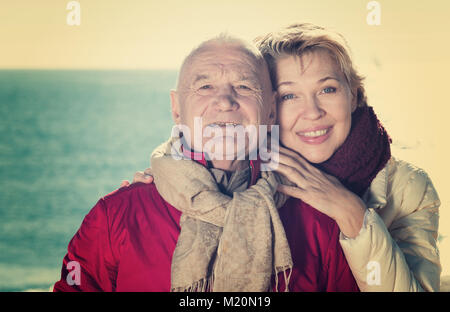 Young couple marche sur la mer par jour frisquet ensoleillé Banque D'Images