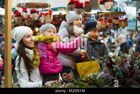 Une famille heureuse avec des enfants l'achat de jouets traditionnels Tio Caga à la juste. L'accent sur fille blonde Banque D'Images