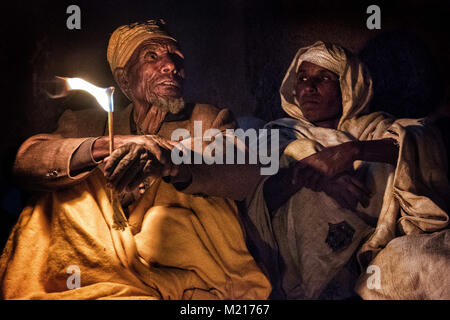 Lalibela, région d'Amhara, en Éthiopie. 6 janvier, 2018. Pèlerins priant avec des bougies allumées dans la nuit à l'extérieur de l'Biete Medhane Alem (Maison du Sauveur du monde).Pendant les premiers jours de janvier, des milliers de pèlerins chrétiens orthodoxes éthiopiens aller à la ville de Lalibela pour visiter la ''Nouvelle Jérusalem''. Cette ville sainte est composée de 11 églises interconnectés sculptée à la main qui sont connectés à travers une série de labyrinthes et des tunnels.Les premiers jours de janvier marquer la célébration de Genna (également connu sous le nom de Ledet), qui est la version de Noël du calendrier éthiopien. Au cours de cette celebra Banque D'Images