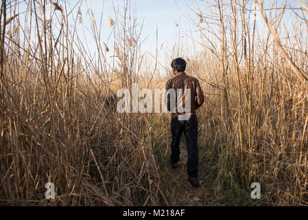 Subotica, Serbie. 24Th Mar, 2017. Un migrants pakistanais un champ d'herbe trought promenades à côté d'une ancienne usine de brique de Subotica.Subotica, situé à 15 km de la frontière hongroise, serbe - un refuge pour des centaines de réfugiés et migrants. La route des Balkans a été officiellement fermé il y a plus d'un an, et pourtant, les alambics reste comme une porte ouverte pour des milliers de migrants et de réfugiés. Pendant ce temps, les migrants en provenance du Pakistan vivent illégalement dans les forêts et des bâtiments abandonnés, qu'ils n'ont pas droit à l'asile. En tant que vivant illégalement ne donne aucun accès à toutes les activités prévues dans les camps officiels et la plupart des o Banque D'Images