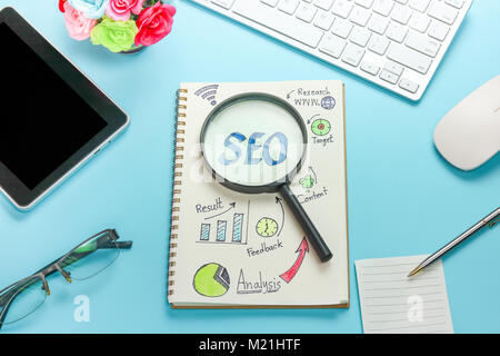 Vue de dessus de la SEO et du papier millimétré avec loupe, l'objet d'affaires et les outils technologiques, de l'argent pièce de monnaie sur la table de travail Banque D'Images