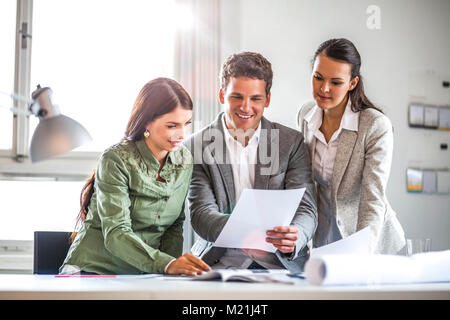 Les gens d'affaires à examiner des documents dans Office Banque D'Images