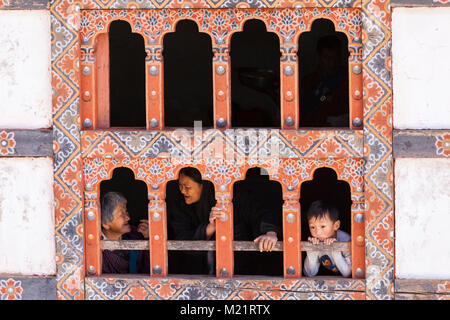Prakhar Lhakhang, Bumthang, Bhoutan. Les femmes et le garçon dans la fenêtre du monastère. Banque D'Images