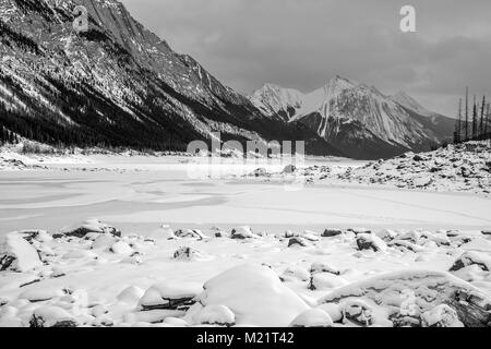 Le format panorama photo d'un paysage hivernal de la médecine lac gelé entouré par les rocheuses canadiennes dans le parc national de Banff, Alberta, Canada Banque D'Images