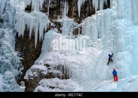 Grimpeur sur glace sur la partie supérieure de la tombe pendant l'hiver, le ruisseau Johnston Canyon Johnston, Banff National Park, Rocheuses canadiennes, l'Alberta, CA Banque D'Images