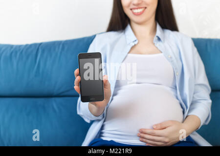 Pregnant woman holding phone avec écran vide Banque D'Images