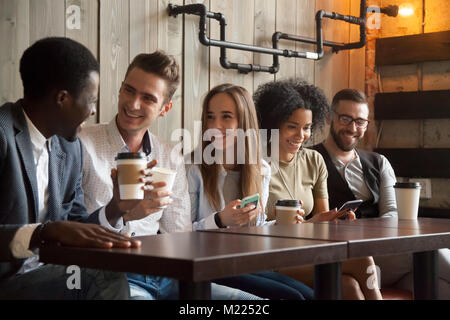 Heureux groupe multiethnique d'amis parler à l'aide de smartphones Banque D'Images