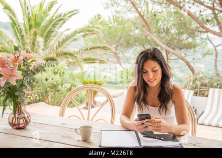 Une femme travaille à l'extérieur du bureau, peut-être en vacances, ou de la maison. Banque D'Images