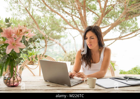 Une femme travaille à l'extérieur du bureau, peut-être en vacances, ou de la maison. Banque D'Images