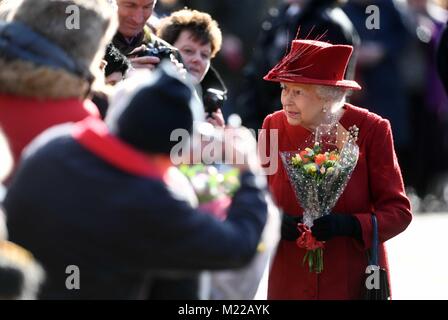 La reine Elizabeth II salue des wellwishers qu'elle fréquente l'église St Pierre et Paul à West Newton, Norfolk, pour un dimanche matin. Banque D'Images