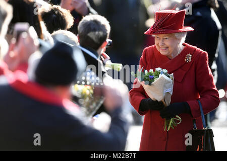 La reine Elizabeth II salue des wellwishers qu'elle fréquente l'église St Pierre et Paul à West Newton, Norfolk, pour un dimanche matin. Banque D'Images