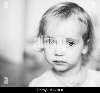 Belle petite fille les yeux dans l'appareil photo aux yeux tristes Banque D'Images