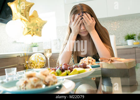 Portrait de jeune femme déprimée pleurer seul à la table du dîner le jour de Valentines, copy space Banque D'Images