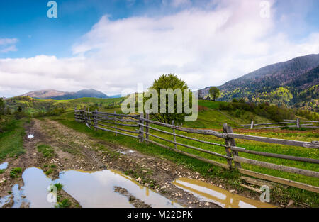 Route de campagne par montagneux région rurale. beau paysage de printemps avec des pentes herbeuses et les champs agricoles Banque D'Images