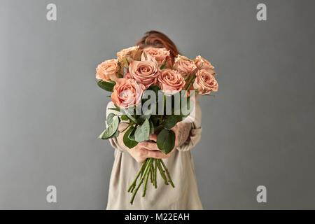 Une femme donne un bouquet de roses beige Banque D'Images