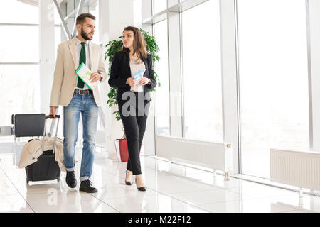 Portrait de beau couple moderne billets d'avion et valise à la porte en l'aéroport moderne, copy space Banque D'Images