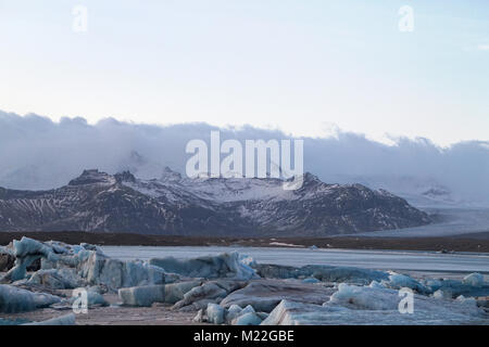 Des icebergs sur la lagune de Jökulsárlón après la rupture du glacier Breiðamerkurjökull de fusion, de l'Islande. Ils ont des couches de cendres volcaniques noires. Banque D'Images