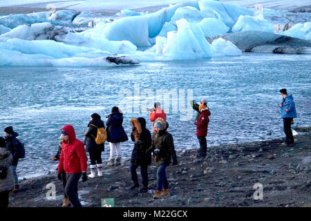 Personnes photographiant les icebergs sur la lagune de Jökulsárlón après la rupture du glacier Breiðamerkurjökull de fusion, de l'Islande. Banque D'Images