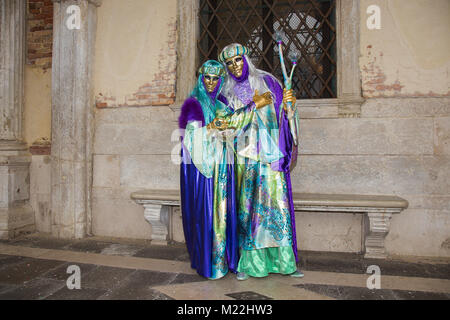 Carnaval de Venise - quel beau couple de masques Vénitiens en costume coloré et élégant sur la Place Saint Marc à Venise. Banque D'Images