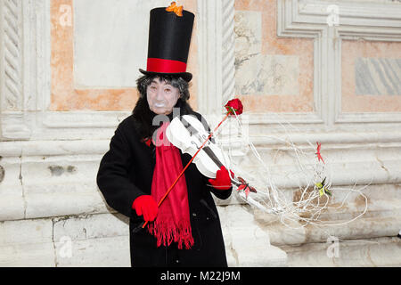 Masque de Venise de Pierrot mâle blanc jouant le violon avec rose rouge sur la place San Zaccaria - Carnaval de Venise Banque D'Images