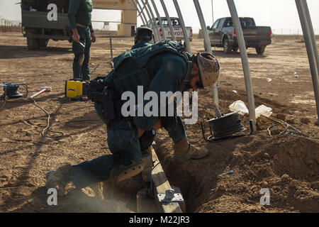 Les membres de la Guardia Civil espagnole de l'équipe de formation, Groupe de travail Besmaya, construire une enceinte le 3 janvier, 2018 à Besmaya complexe de formation, de l'Iraq. Le groupe de travail dirigé par l'espagnol est la formation de la Force de garde-frontières iraquiennes dans la construction et l'exploitation d'avant-postes frontaliers, ainsi que l'emploi des ensembles d'équipement standardisé appelé garde-frontière dans une boîte. La frontière irakienne Force de garde est chargé de contrôler les mouvements à travers la frontière et empêcher l'infiltration de terroristes. Besmaya complexe de formation est l'un des nombreux lieux de formation soutenu par la Force opérationnelle interarmées - Fonctionnement inhérentes Banque D'Images