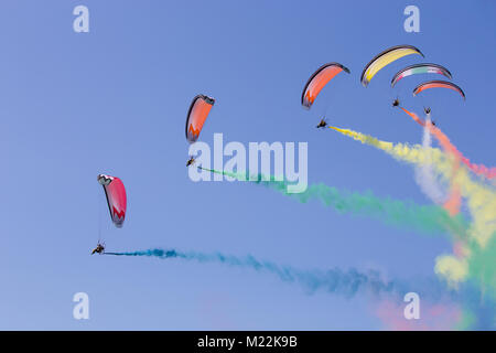 Airshow du de parachute avec multicolores. Au cours de la performance des parachutistes de l'air avec sentier des couleurs du drapeau italien dans le ciel bleu clair. Banque D'Images
