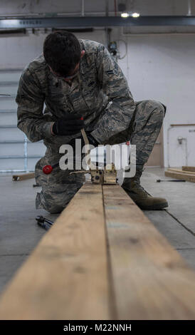 Navigant de première classe Landon Gonzales, 2e Escadron de munitions munitions classiques de l'équipage, les bandes bois ensemble à base aérienne de Barksdale, en Louisiane, le 30 janvier 2017. Les bandes autour du bois le fixer en place pour assurer la sécurité du bâtiment la aviateurs des bombes. (U.S. Air Force Banque D'Images