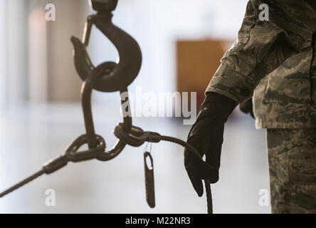 Navigant de première classe Landon Gonzales, 2e Escadron de munitions munitions classiques, membre de l'équipage est titulaire d'un câble avant il est attaché à une bombe au corps de base aérienne de Barksdale, en Louisiane, le 30 janvier 2017. Les câbles sont attachés à un chariot élévateur pour soulever le corps de bombes de la palette et les déplacer vers un autre domaine pour l'assemblage. (U.S. Air Force Banque D'Images