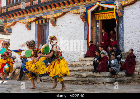 Prakhar Lhakhang, Bumthang, Bhoutan. Les jeunes moines bouddhistes en porte et sur les étapes du monastère des moines plus âgés regardent exécuter une danse dans le Duechoed Relig Banque D'Images