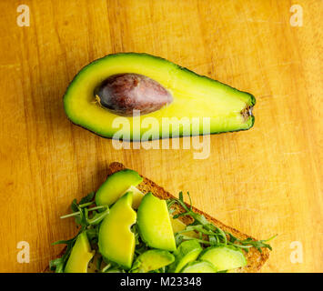 Toast à l'avocat avec rucolla sur table en bois. Banque D'Images