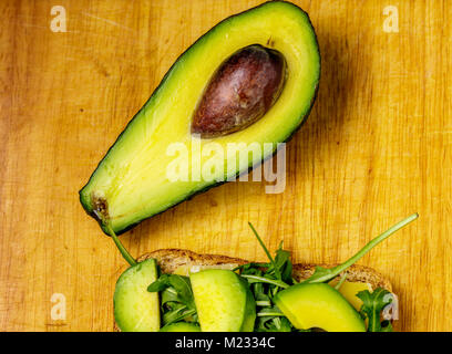 Toast à l'avocat avec rucolla sur table en bois. Banque D'Images