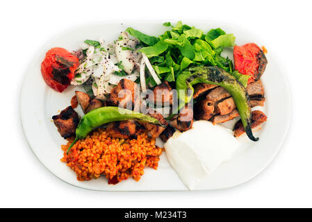 Assiette de viande d'agneau shish avec l'oignon, le riz, les tomates et le poivron rôti sur un fond blanc. Banque D'Images