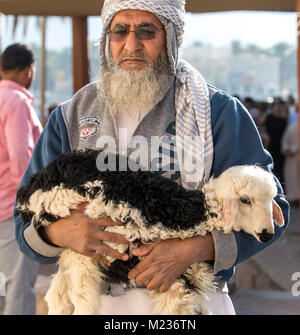 Nizwa, Oman, le 2 février 2018 : vieil homme waling loin d'un marché avec une chèvre bébé Banque D'Images