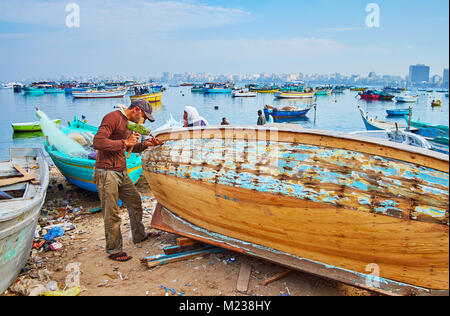 Alexandrie, Egypte - Décembre 17, 2017 : Le jeune ouvrier répare le vieux bateau en bois, il les correctifs de petits trous sur les rives du port est, sur Décembre 20 01 Banque D'Images