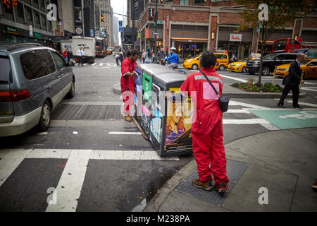 New York City Manhattan, Times Square street cleaners le déplacement d'une poubelles de recyclage Banque D'Images