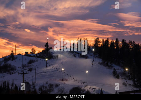 Vue sur d'une piste de ski éclairée pour le ski nocturne à Steamboat Springs, Colorado ; après le coucher du soleil ; ciel coloré à l'arrière-plan Banque D'Images