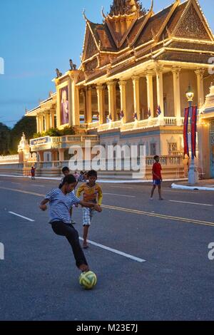 Fille et les enfants cambodgiens sur maison flottante, Kompong Chhnang, Cambodge jouant au football dans l'avant du Palais Royal, Phnom Penh, Cambodge Banque D'Images