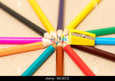 Crayons de couleur multi-plié dans un cercle et un taille-crayon jaune Banque D'Images