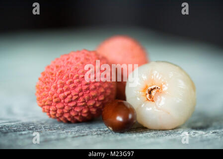 Trois fruits litchi et de semences sur fond de bois Banque D'Images