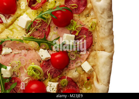 Vue rapprochée de la pizza avec de la saucisse, jambon, tomates cerise et mozzarella Banque D'Images