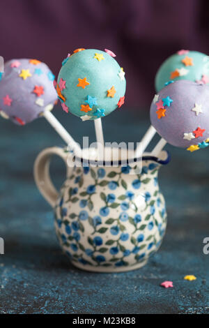 Des сolorful Cake pops avec des étoiles sur un fond en bois bleu, selective focus Banque D'Images