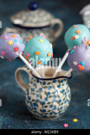 Des сolorful Cake pops avec des étoiles sur un fond en bois bleu, selective focus Banque D'Images