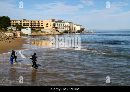 Les amateurs de plongée sous-marine à San Carlos Beach, waterfront hôtels à la distance, Monterey, California, United States Banque D'Images