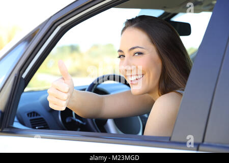 Portrait d'un pilote satisfait gesturing Thumbs up assis à l'intérieur d'une voiture Banque D'Images