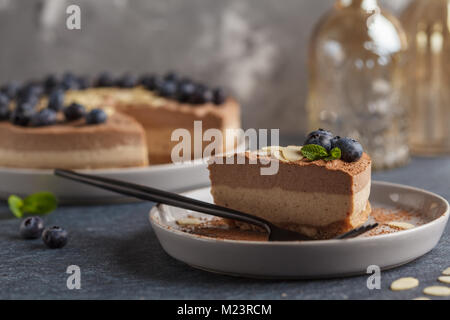 Végétalien premières chocolat-caramel cheesecake aux myrtilles et amandes. Dessert vegan sain concept alimentaire. Banque D'Images