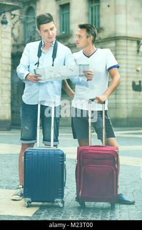 Deux gars souriant positives à la recherche sur la carte Banque D'Images